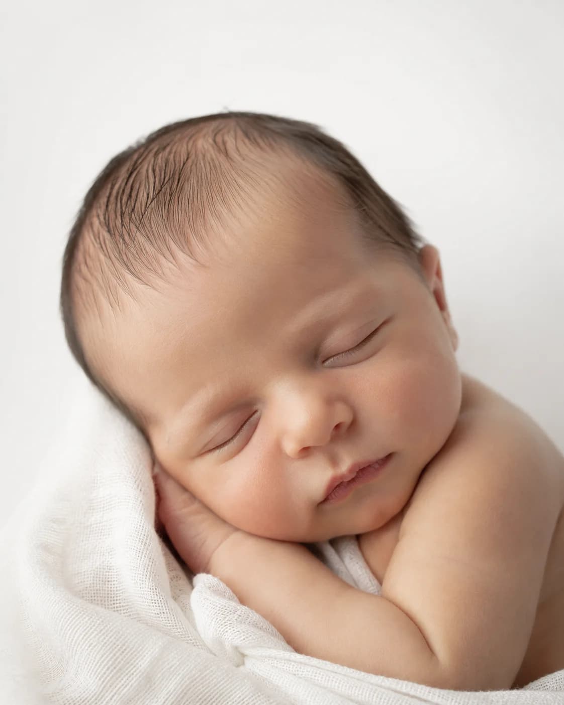 Portrait en gros plan d'un nouveau-né aux traits délicats, lumière naturelle douce, esthétique intemporelle et élégante